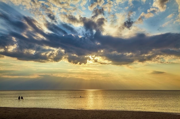 人々のグループは 素晴らしい空を背景に日没時に暖かい海で泳ぎます プレミアム写真 人々のグループは 素晴らしい空を背景に日没時に暖かい海で泳ぎます プレミアム写真