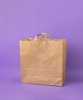 紫​の​背景​に​大きな​紙​の​買い物袋​。