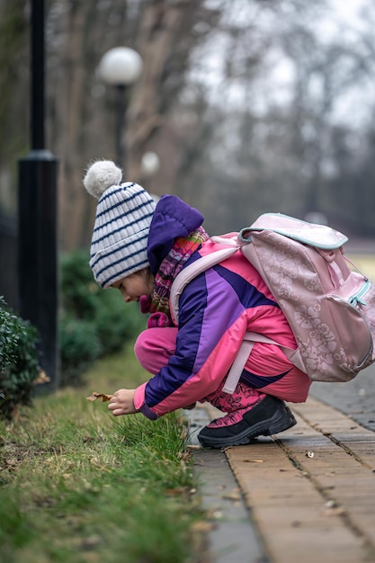 寒い季節の外の葉を見る少女