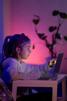 어린 소녀는 밤 늦게 노트북을 사용합니다