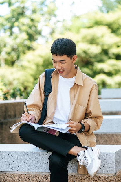 座って階段で本を読む男。