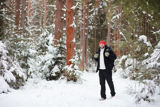Человек путешествует с рюкзаком. зимний поход в лес. турист на прогулке зимой в парке. Premium Фотографии