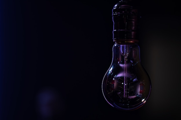 Бесплатное фото Несветящаяся лампа висит на темном размытом фоне копировального пространства.