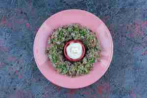 Бесплатное фото Розовая тарелка фарша с горошком и зеленью