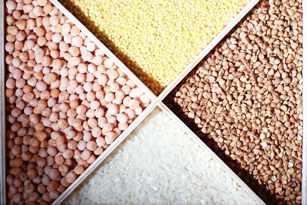 Набор зерновых круп. рис, гречка и пшенная крупа в деревянном подносе. продуктовый набор круп. импорт зерна.