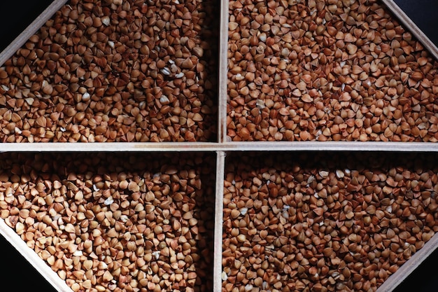 Набор зерновых круп. рис, гречка и пшенная крупа в деревянном подносе. продуктовый набор круп. импорт зерна.