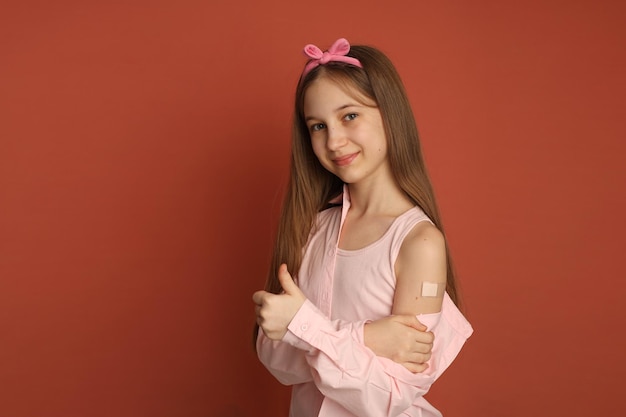 予防​接種後​に​腕​に​パッチ​を​当てた​10​代​の​少女​少女​は​テキスト​ワクチン​接種​の​ため​の​スペース​を​眉​を​ひそめる