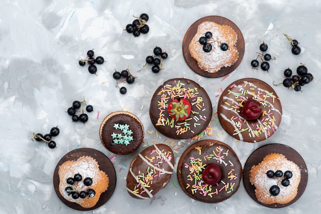 Бесплатное фото Вид сверху торты и пончики шоколадные на основе фруктов и конфет торт бисквитный