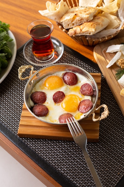 Бесплатное фото Колбаса, вид сверху, яйца, чай и буханки хлеба на столе в ресторане, еда, завтрак