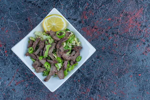 Бесплатное фото Белая тарелка с вкусным мясом и зеленью.