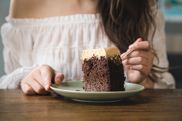 無料写真 女性がチョコレート ケーキのクローズ アップを食べる