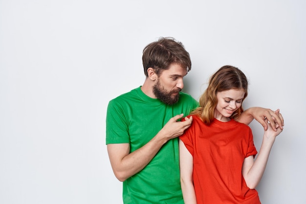 若い​カップル​が​友情​を​抱きしめる​カラフル​な​tシャツ​家族​の​スタジオ​の​ライフスタイル