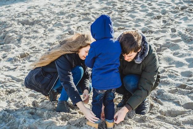 無料写真 子供がいる若い家族は、冷たいバルト海の海岸で週末を過ごす