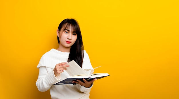 Молодая женщина читает книгу и думает, как в кино. на желтом фоне