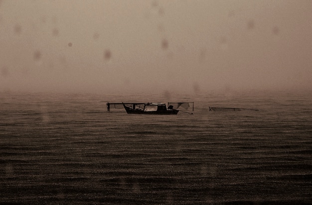 Free photo abandoned boat rainy dark sea