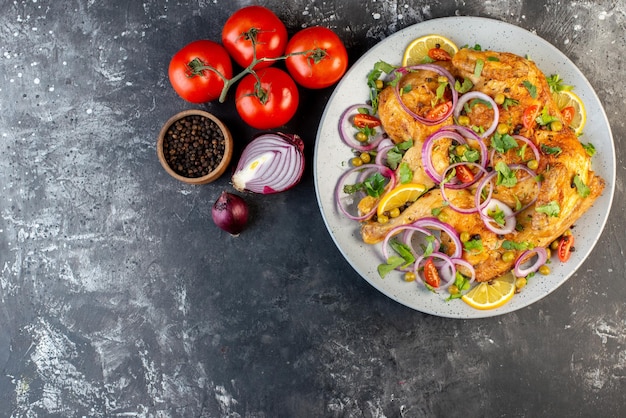 무료 사진 다양한 향신료와 음식 토마토를 곁들인 맛있는 저녁 튀긴 치킨 요리의 보기 위에 어두운 색 배경의 왼쪽에 고추 양파 줄기가 있습니다