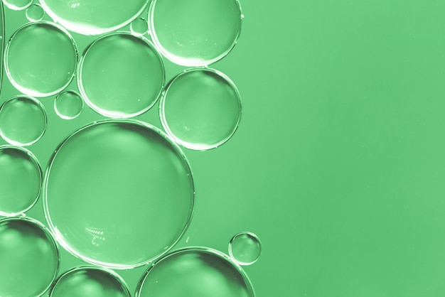 緑色の背景で液体の抽象的な空気泡