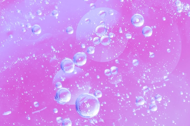 Abstract air bubbles in oil drop on pink blurred background