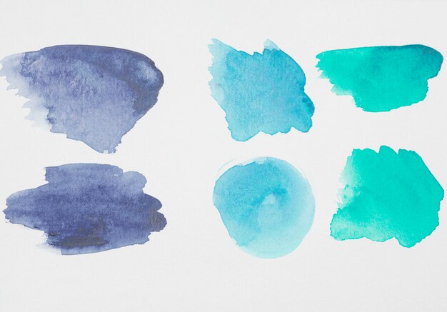 Abstract aquamarine and blue spots of paints on white paper