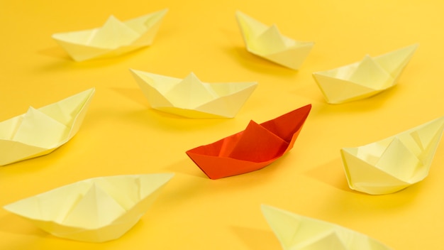 Free photo abstract arrangement with paper boats on yellow background