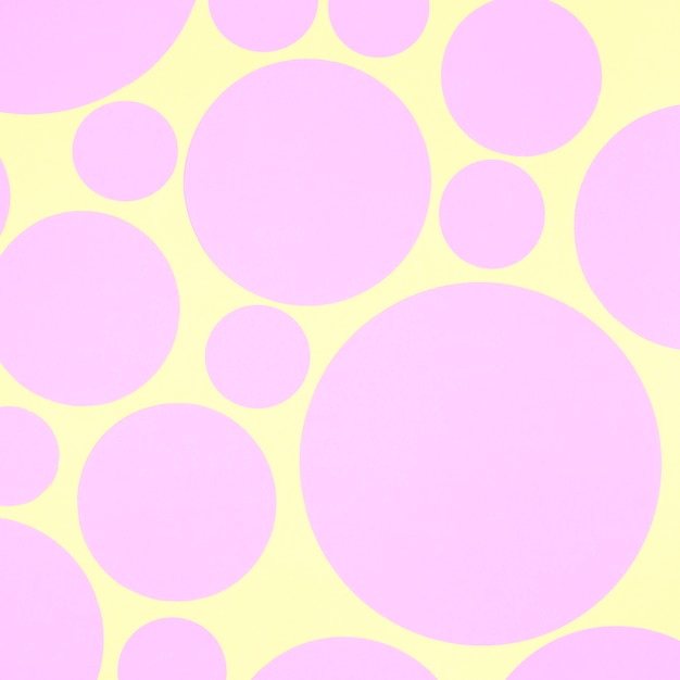 Abstract background with pink paper circle elements on yellow backdrop