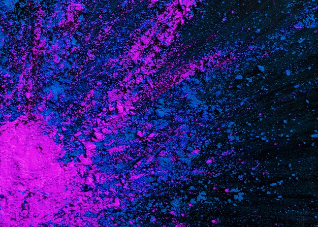 Abstract blue and pink dry holi colors splatted on black background