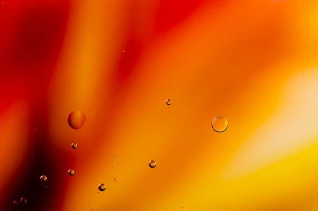 さまざまな透明な雨滴と抽象的な色付きの背景