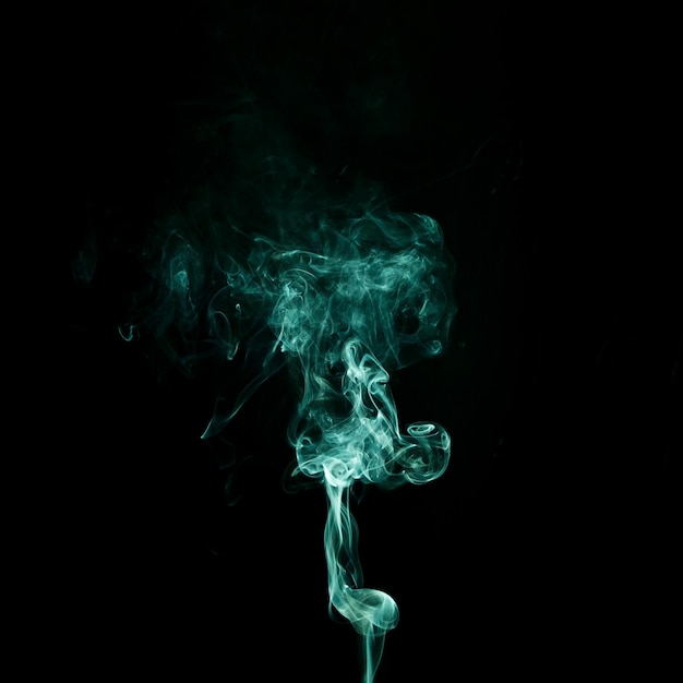 Абстрактный зеленый дым кружится на черном фоне