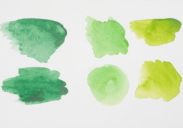 Abstract green spots of paints on white paper