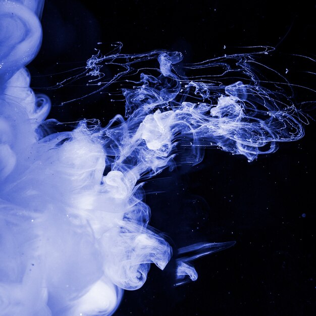 Abstract heavy blue fog in dark liquid