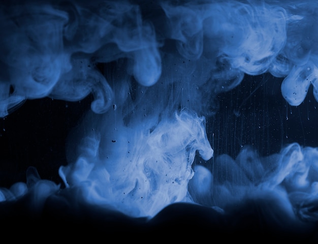 Abstract heavy blue smoke in dark liquid