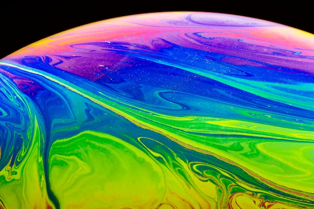 Abstract iridescent soap bubble on black background
