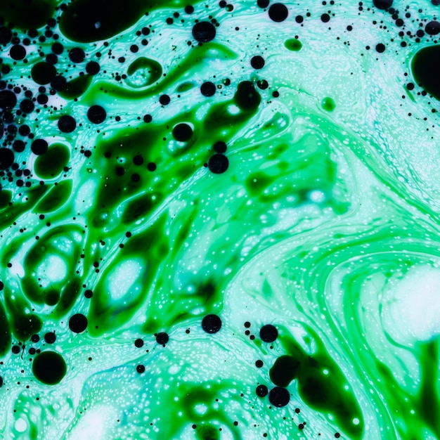 Abstract mixture of green and black ink