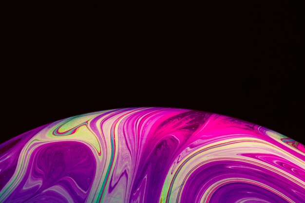 Abstract multicolored saturated soap bubble on black background