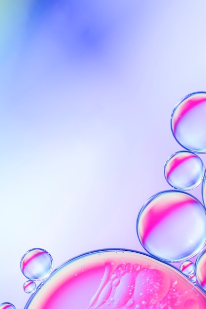 Free photo abstract oil drops in fluid on multicolored defocused background