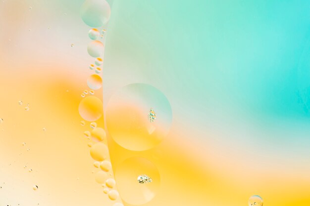 Abstract pattern of coloured oil bubbles on water