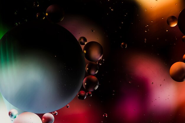 Abstract pattern of coloured oil bubbles on water