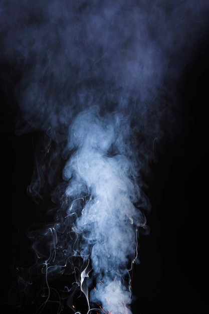 The abstract pattern made from smoke rising from an incense stick on black background