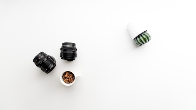 Abstract photo with camera lenses coffee and cactus plant sideways