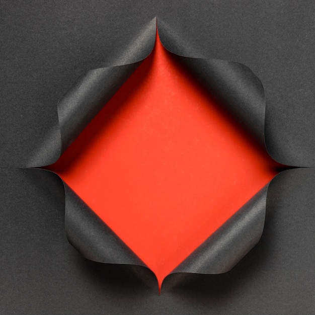 Abstract red shape on torn black paper