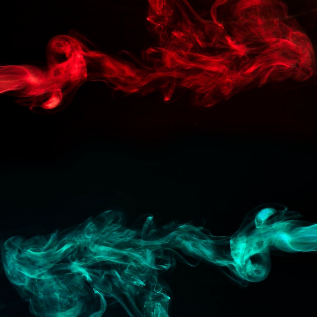 Абстрактный красный и бирюзовый дым на черном темном фоне