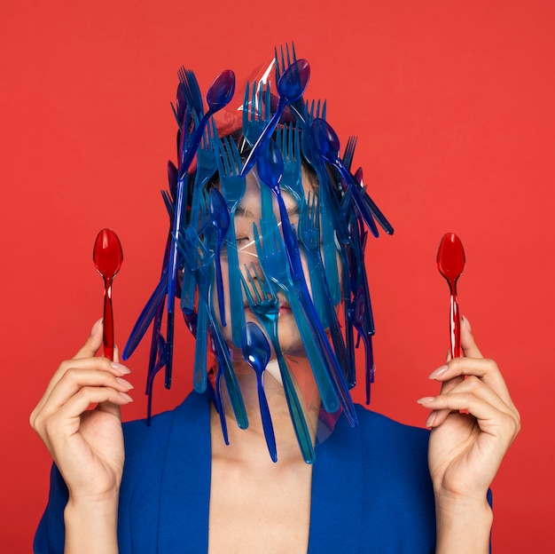 Free photo abstract representation of blue plastic tableware waste on young woman