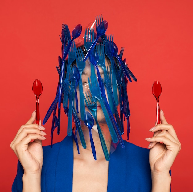 젊은 여자에 파란색 플라스틱 식기 폐기물의 추상 표현