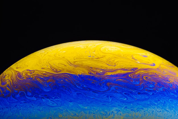 Free photo abstract saturated vibrant soap bubble on black background