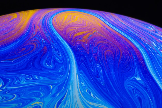 Abstract vibrant rippled soap bubble on black background