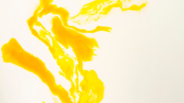 白い背景の上の抽象的な黄色とオレンジ色の汚れ