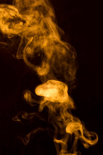 Abstract of yellow transparent smoke fumes on black background