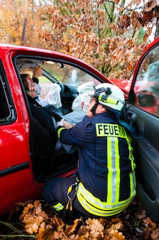 Несчастный случай, пожарная команда спасает жертву автомобильной катастрофы