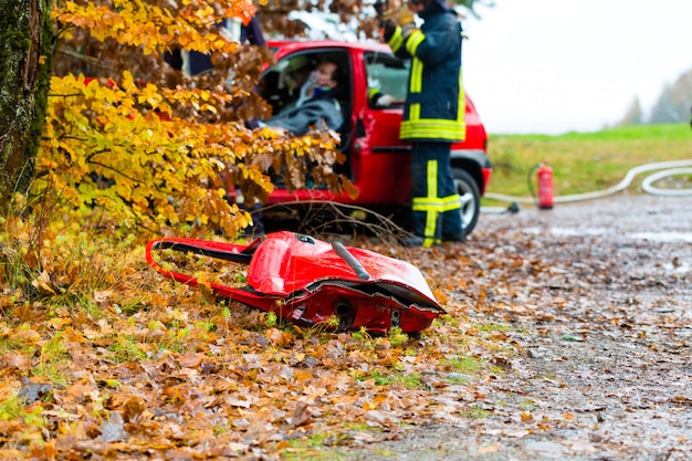 Несчастный случай, пожарная команда спасает жертву автомобиля