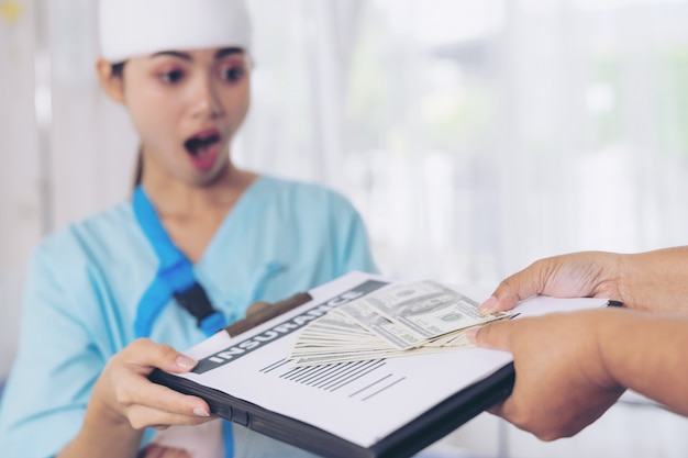 Foto gratuita donna di infortunio di pazienti infortunati sul letto del paziente in ospedale con banconote da un dollaro ci sentiamo felici dall'ottenere denaro assicurativo da compagnie assicurative